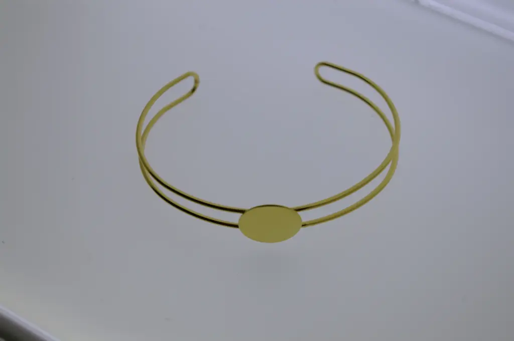 Brazalete de hilo con disco soldado. Baño dorado.